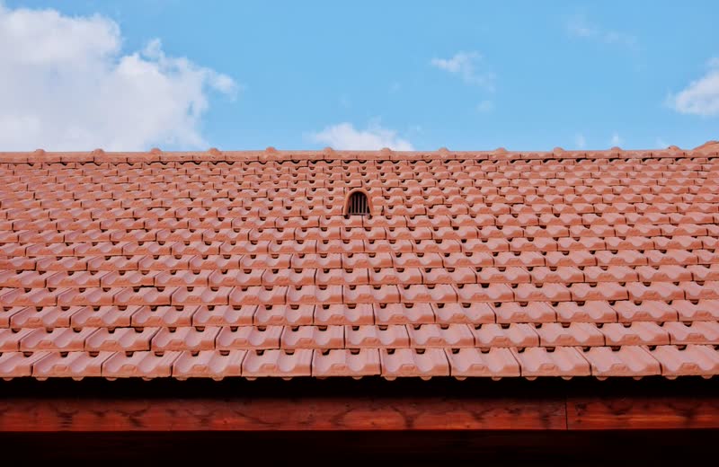 Terracotta clay tile roof against a blue sky
