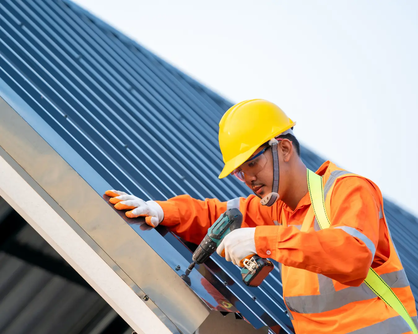 Commercial roofing installer fastening a metal roof system