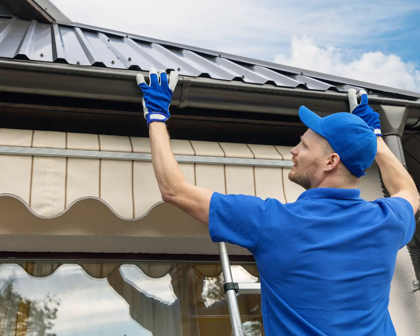 Commercial roofing technician working on a metal roof edge