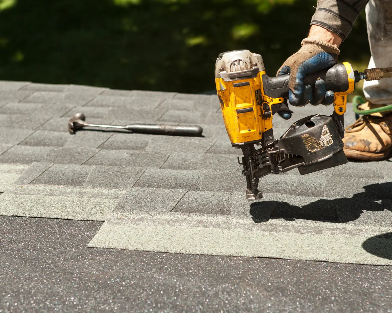 Roofer installing new shingles during a commercial roof replacement