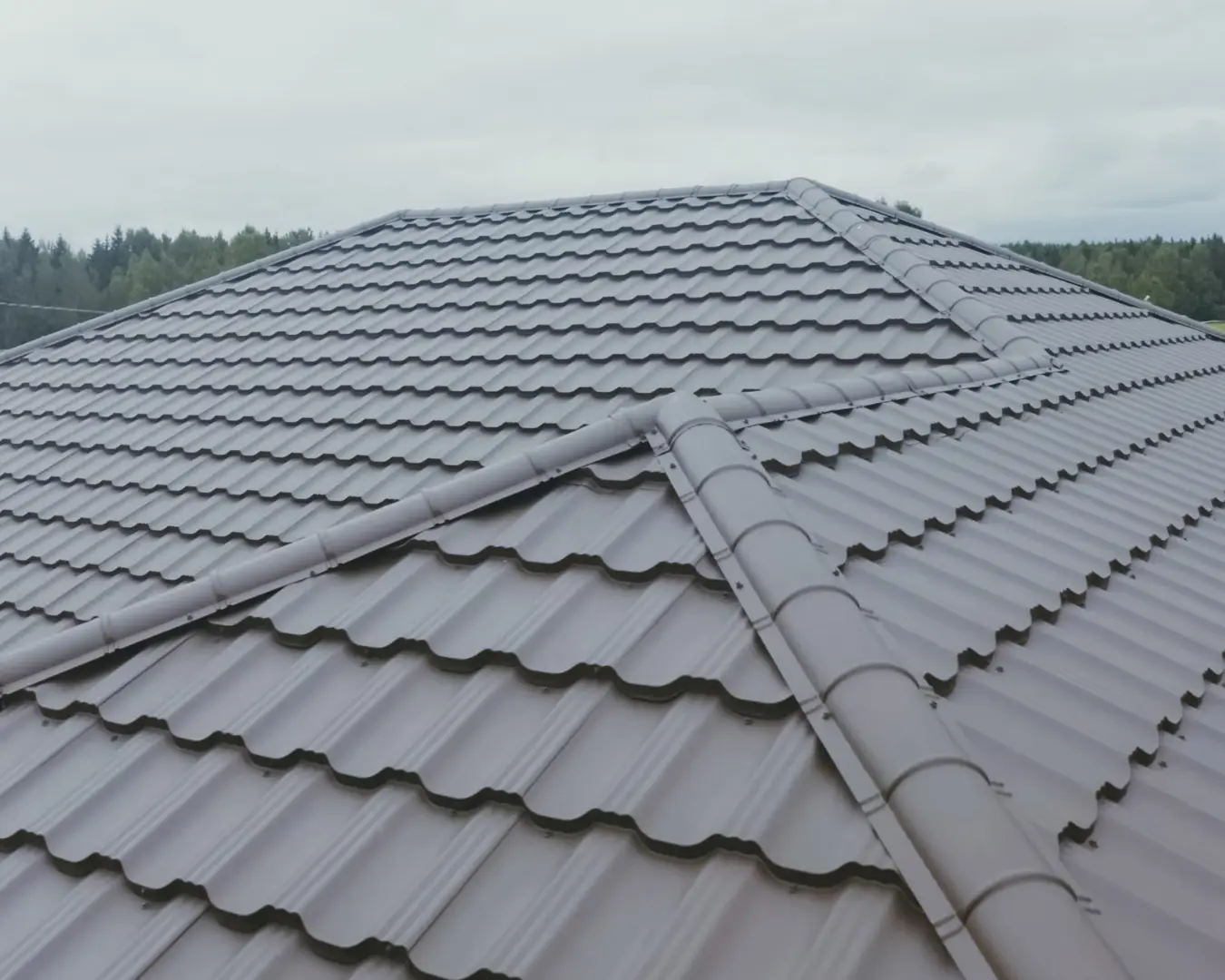 Tile-profile metal roofing installed across intersecting hips and valleys