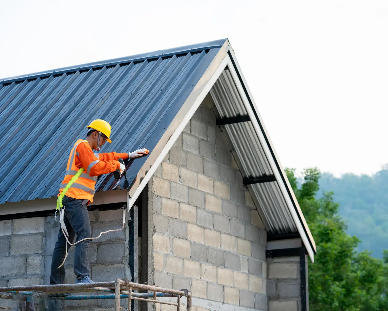 Roofer installing a standing-seam metal roof on a new build