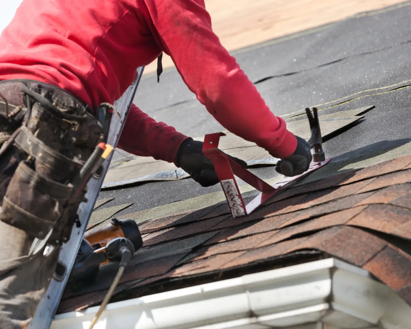 Ragsdale-style roofer hand-nailing architectural shingles on a residential roof